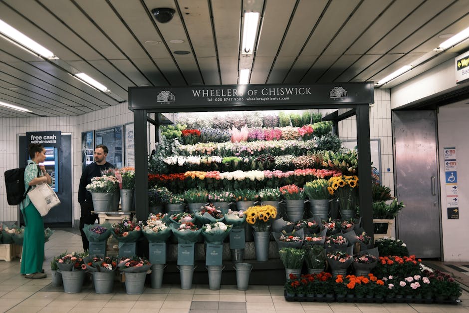 A vibrant floral display at Wheeler of Chiswick located in a London underground station, featuring an arrangement of fresh flowers including pink, white, red, yellow, and purple blooms organized in bu