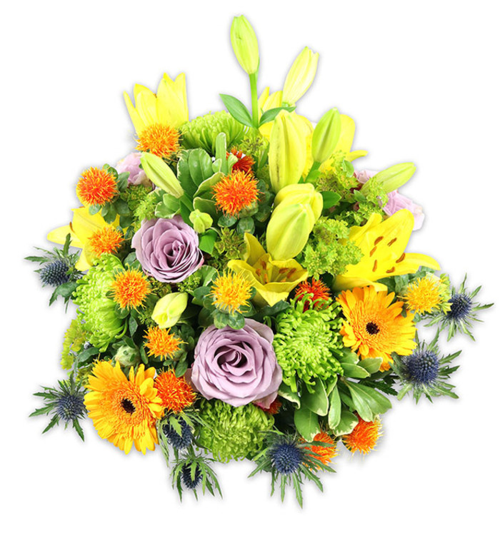 Set on a crisp white field that lets each hue sing, this densely packed bouquet blends warmth and a touch of cool restraint in a composition that feels both classic and contemporary. Dominant yellow Asiatic lilies create an upward rhythm: some blooms are open and generous, their pencilled speckles and exposed stamens lending delicate detail, while elongated buds introduce anticipation and sculptural height. Two or three soft lavender roses offer a refined focal calm in the centre, their velvety spirals absorbing light and scent, contrasting with the vivacity of large orange Gerbera daisies whose radiating petals draw the eye outward. Bright lime-green button chrysanthemums fill and cushion the design with a textured, almost moss-like quality, while small, globe-like orange and golden-yellow accents add lively, spiky pops that make the bouquet feel playful and tactile. The cool punctuation comes from several steel-blue Eryngium thistles positioned along the lower and side margins - their star-like bracts and bristly centers give a crisp architectural edge against the softer flower shapes. A layered selection of foliage - broad lily leaves, glossy fillers and fine-stemmed greenery - supports the arrangement, creating shadow, depth and a living frame around the flowers. In gentle morning light the bouquet reads as celebration and solace at once: ideal for anniversary tables, cheerful home display, or a considered sympathy offering. A skilled local florist would bring this to a Barkingside flat near Hainault Forest or a family home off Fairlop Road, where its colours reflect late-spring optimism and thoughtful craftsmanship.